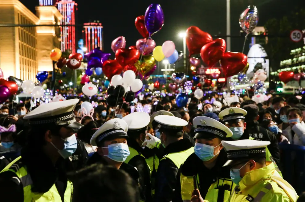 People hold balloons as they gather to celebrate the arrival of the new year during the coronavirus disease (COVID-19) outbreak in Wuhan, China December 31, 2020. REUTERS/Tingshu Wang[[[REUTERS VOCENTO]]] HEALTH-CORONAVIRUS/NEWYEAR-WUHAN