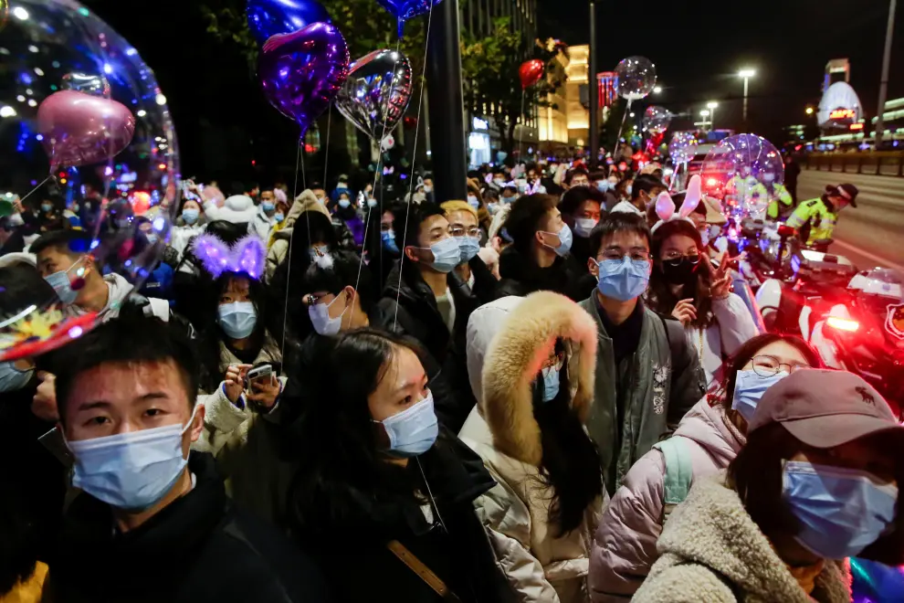 Police officers stand guard as people gather to celebrate the arrival of the new year during the coronavirus disease (COVID-19) outbreak in Wuhan, China December 31, 2020. REUTERS/Tingshu Wang[[[REUTERS VOCENTO]]] HEALTH-CORONAVIRUS/NEWYEAR-WUHAN
