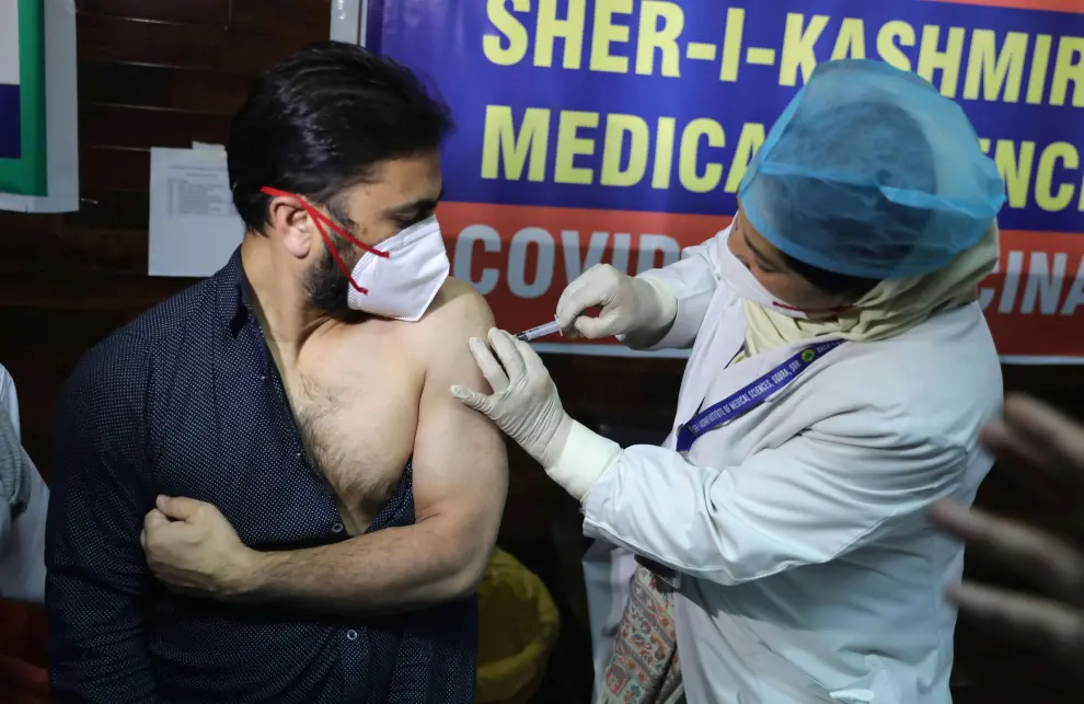 Srinagar (India), 16/01/2021.- A Kashmiri doctor receives a COVID-19 vaccine shot, manufactured by Serum Institute of India, in Srinagar, the summer capital of Indian Kashmir, 16 January 2021. One of the world's biggest and nationwide COVID-19 vaccination drive launched by Indian prime minister Narendra Modi and aimed at inoculating 30 million people starts in first drive that include front line workers like Accredited Social Health Activist (ASHA) doctors, MBBS students, nurses etc. EFE/EPA/FAROOQ KHAN COVID-19 vaccination drive in Indian Kashmir