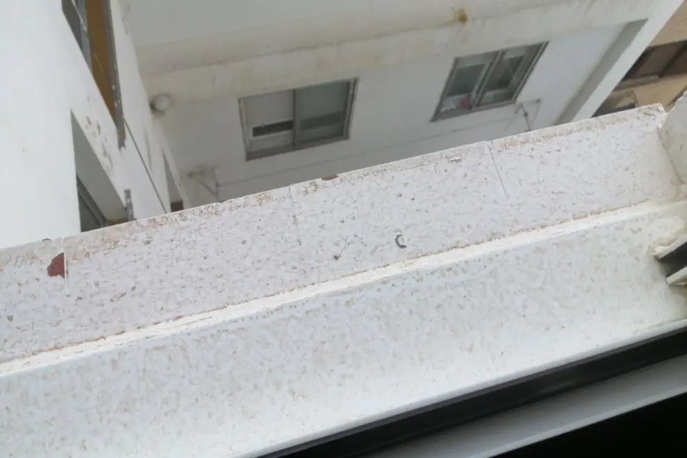 Así ha dejado la lluvia de barro una repisa de la ventana en Zaragoza.