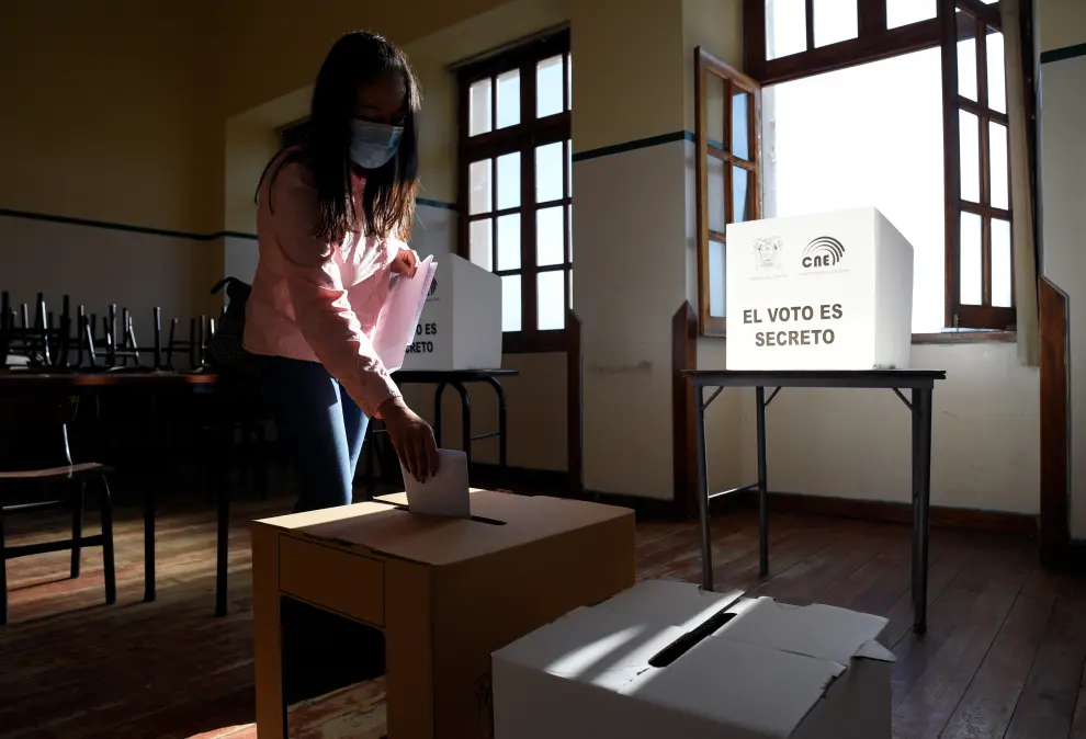 A woman casts her vote at a polling station during the presidential election, in Quito, Ecuador February 7, 2021. The writing on the ballot box reads The ECUADOR-ELECTION/