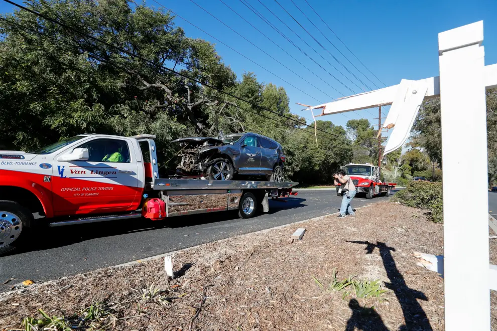 A sign post damaged by the car crash of Tiger Woods is seen as the car is towed away near Los Angeles, California, U.S., February 23, 2021. REUTERS/Mario Anzuoni[[[REUTERS VOCENTO]]] PEOPLE-WOODS/