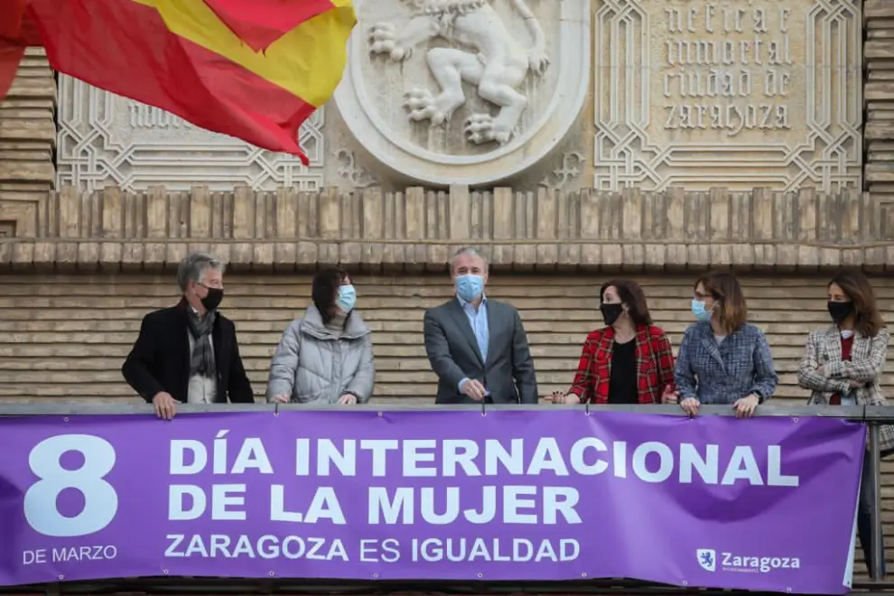Imágenes de la colocación de la pancarta por el Día de la Mujer en el Ayuntamiento de Zaragoza, en la que han participado todos los grupos municipales excepto Vox y Podemos.