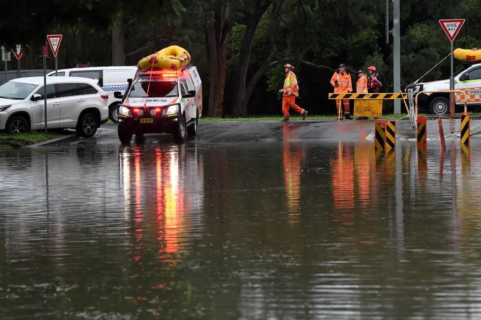 People gather on a flooded street in the suburb of Windsor as the state of New South Wales experiences widespread flooding and severe weather, in Sydney, Australia, March 22, 2021.  REUTERS/Loren Elliott[[[REUTERS VOCENTO]]] AUSTRALIA-WEATHER/