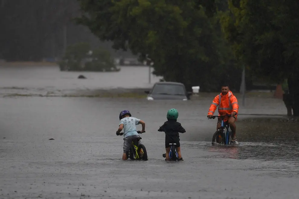 A woman looks out toward a submerged structure visible in floodwaters in the suburb of Windsor as the state of New South Wales experiences widespread flooding and severe weather, in Sydney, Australia, March 22, 2021.  REUTERS/Loren Elliott[[[REUTERS VOCENTO]]] AUSTRALIA-WEATHER/