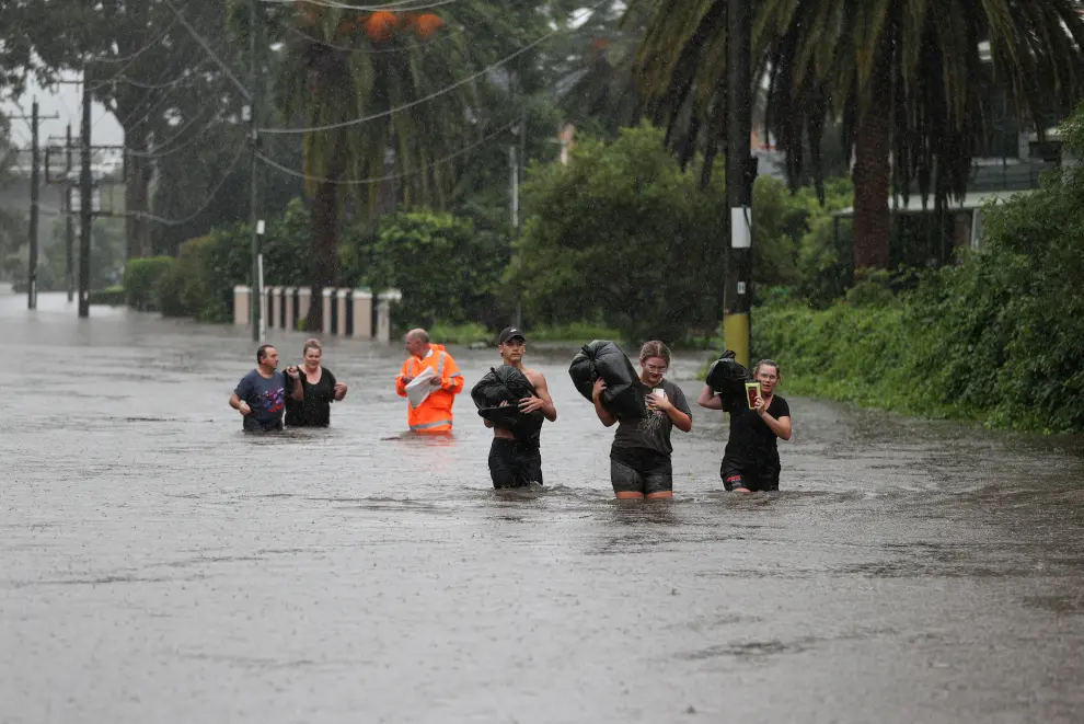 A local resident and his dog are brought to safety by a State Emergency Service rescue team in the midst of widespread flooding and severe weather across the state of New South Wales, in Sydney, Australia, March 21, 2021.  REUTERS/Loren Elliott[[[REUTERS VOCENTO]]] AUSTRALIA-WEATHER/