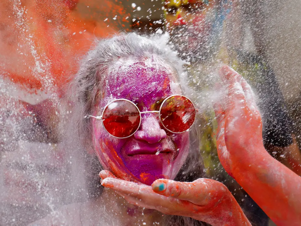 A woman daubed in colours reacts as colour powder is thrown towards her during Holi celebrations in Chennai, India, March 29, 2021. REUTERS/P. Ravikumar[[[REUTERS VOCENTO]]] FESTIVAL-HOLI/INDIA