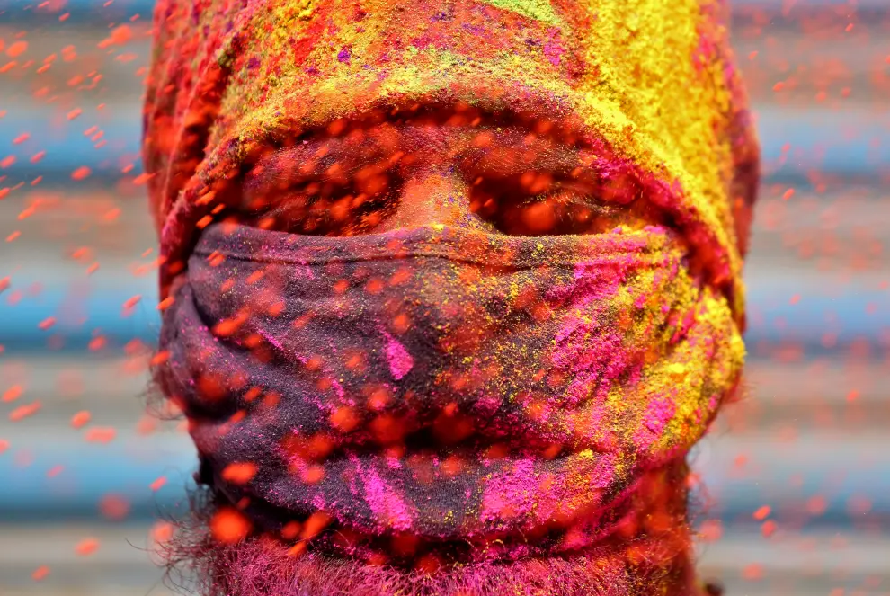 A woman blows colour powder during Holi celebrations, amidst the spread of the coronavirus disease (COVID-19), in Ahmedabad, India, March 29, 2021. REUTERS/Amit Dave[[[REUTERS VOCENTO]]] FESTIVAL-HOLI/INDIA