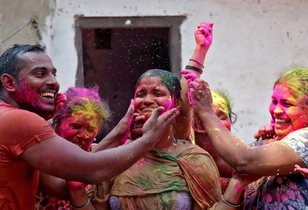 Men cheer as they raise their hands daubed in colours during Holi celebrations, amidst the spread of the coronavirus disease (COVID-9), in Prayagraj, India, March 29, 2021. REUTERS/Jitendra Prakash[[[REUTERS VOCENTO]]] FESTIVAL-HOLI/INDIA
