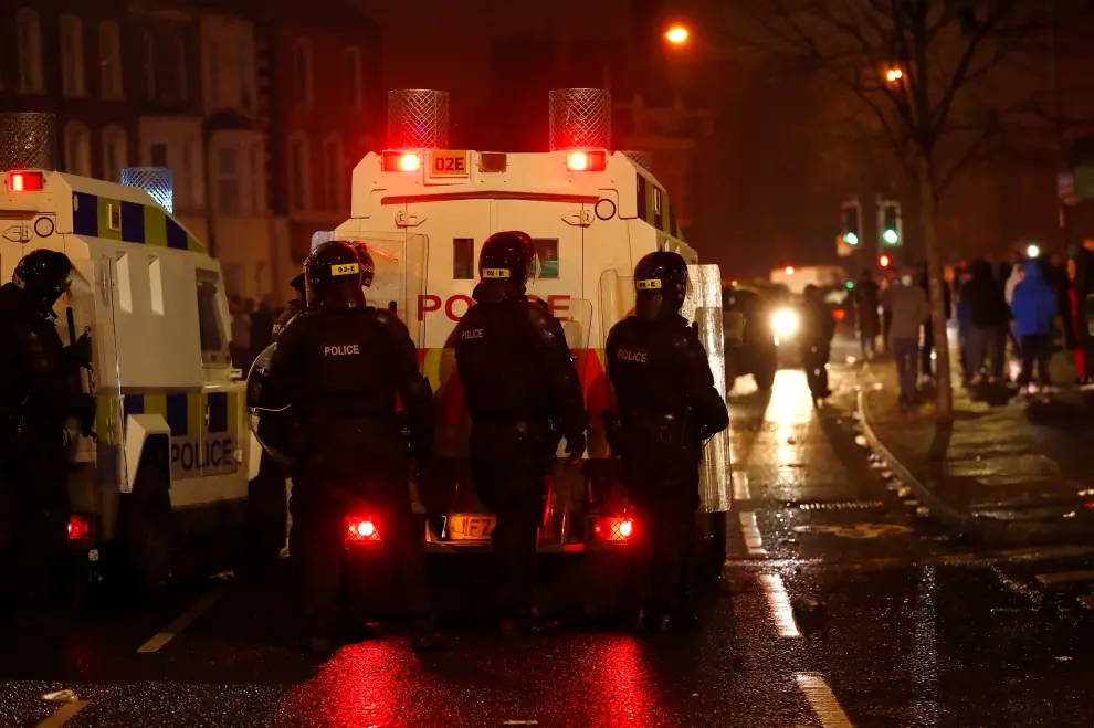 Police officers standing behind shields walk along Springfield Road as protests continue in Belfast, Northern Ireland, April 7, 2021. REUTERS/Jason Cairnduff[[[REUTERS VOCENTO]]] BRITAIN-NIRELAND/PROTESTS