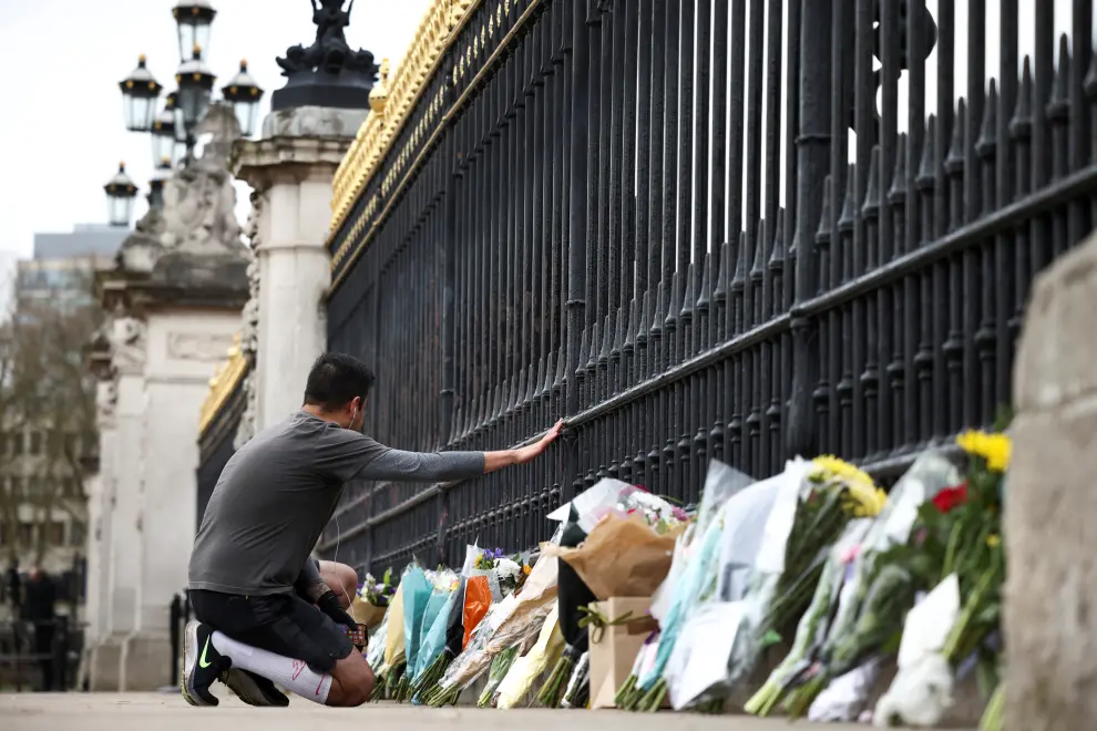 A mourner brings flowers to Buckingham Palace after Britain's Prince Philip, husband of Queen Elizabeth, died at the age of 99, in London, Britain, April 10, 2021. REUTERS/Henry Nicholls[[[REUTERS VOCENTO]]] BRITAIN-ROYALS/PHILIP-BUCKINGHAM PALACE
