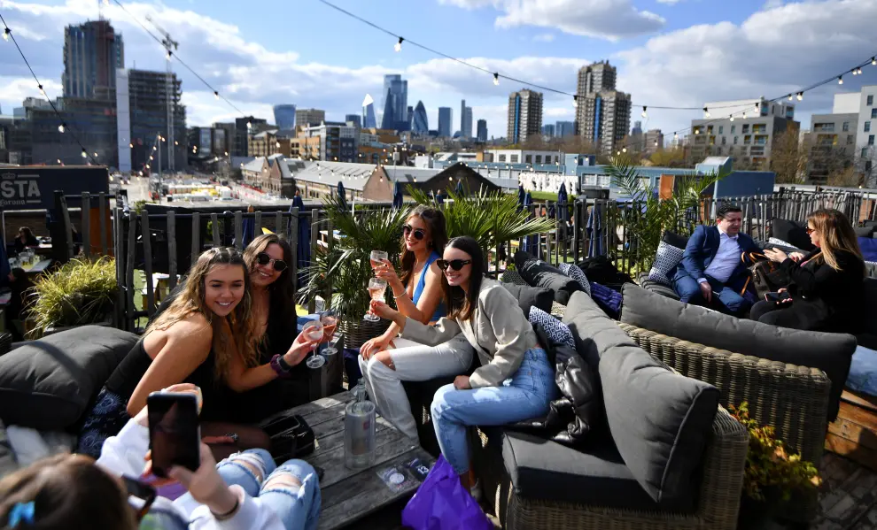 People sit at the Skylight rooftop bar as the coronavirus disease (COVID-19) restrictions ease, in London, Britain April 12, 2021. REUTERS/Dylan Martinez[[[REUTERS VOCENTO]]] HEALTH-CORONAVIRUS/BRITAIN-REOPENING
