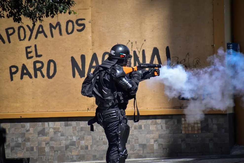 05 May 2021, Colombia, Bogota: A demonstrator stands in front of security forces during rioting following a protest against President Duques government and police violence. Photo: Sergio Acero/colprensa/dpa..05/05/2021 ONLY FOR USE IN SPAIN[[[EP]]] 05 May 2021, Colombia, Bogota: A demonstrator stands in front of security forces during rioting following a protest against President Duque's government and police violence. Photo: Sergio Acero/colprensa/dpa