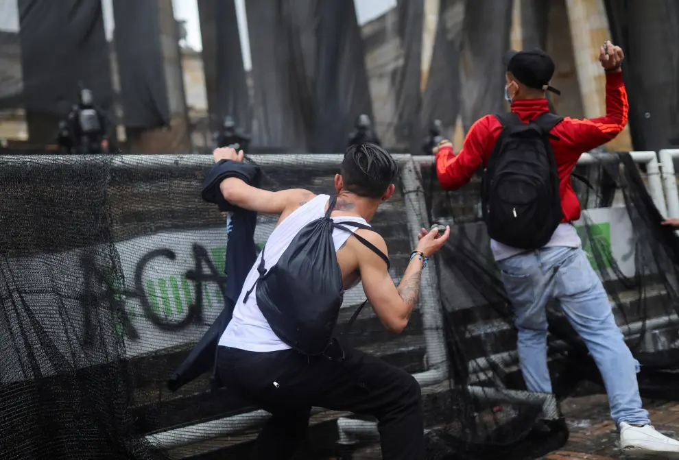 Demonstrators take cover as they clash with police officers during a protest against poverty and police violence in Bogota, Colombia, May 5, 2021. REUTERS/Luisa Gonzalez[[[REUTERS VOCENTO]]] COLOMBIA-PROTESTS/