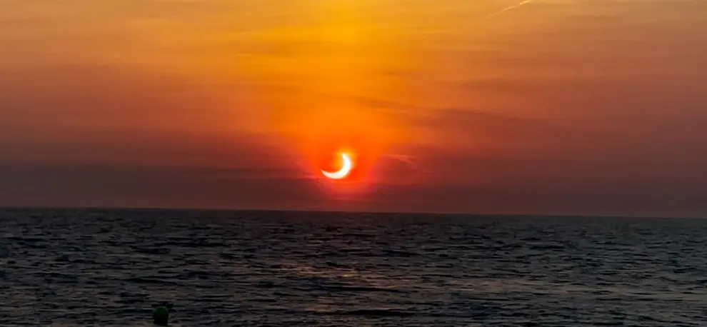 Partial solar eclipse is seen above the horizon in Avon-by-the-Sea
