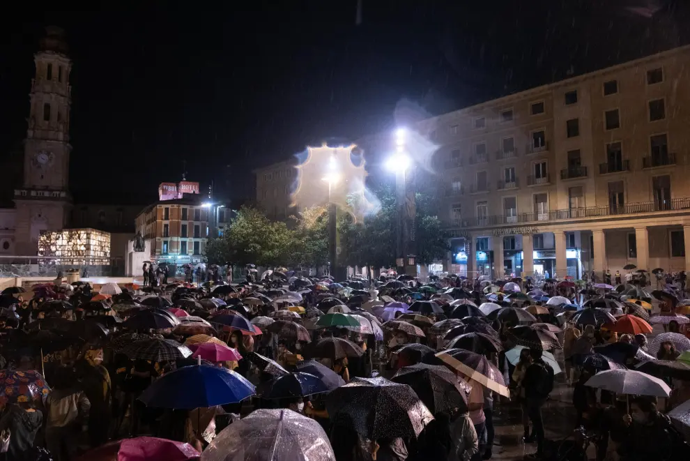 Cientos de personas se han concentrado este viernes en la plaza del Pilar de Zaragoza pese a la intensa lluvia.