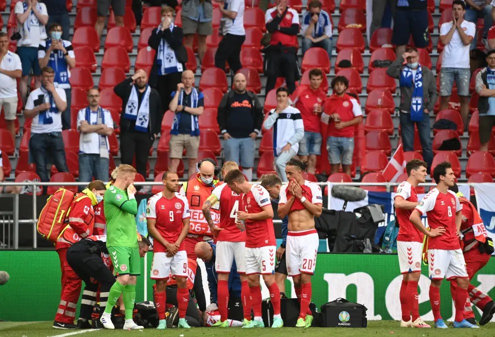 Soccer Football - Euro 2020 - Group B - Denmark v Finland - Parken Stadium, Copenhagen, Denmark - June 12, 2021 Denmarks Thomas Delaney, Andreas Christensen and teammates stand in front of Christian Eriksen as he receives medical attention after collapsing during the match Pool via REUTERS/Wolfgang Rattay[[[REUTERS VOCENTO]]] SOCCER-EURO-DNK-FIN/REPORT