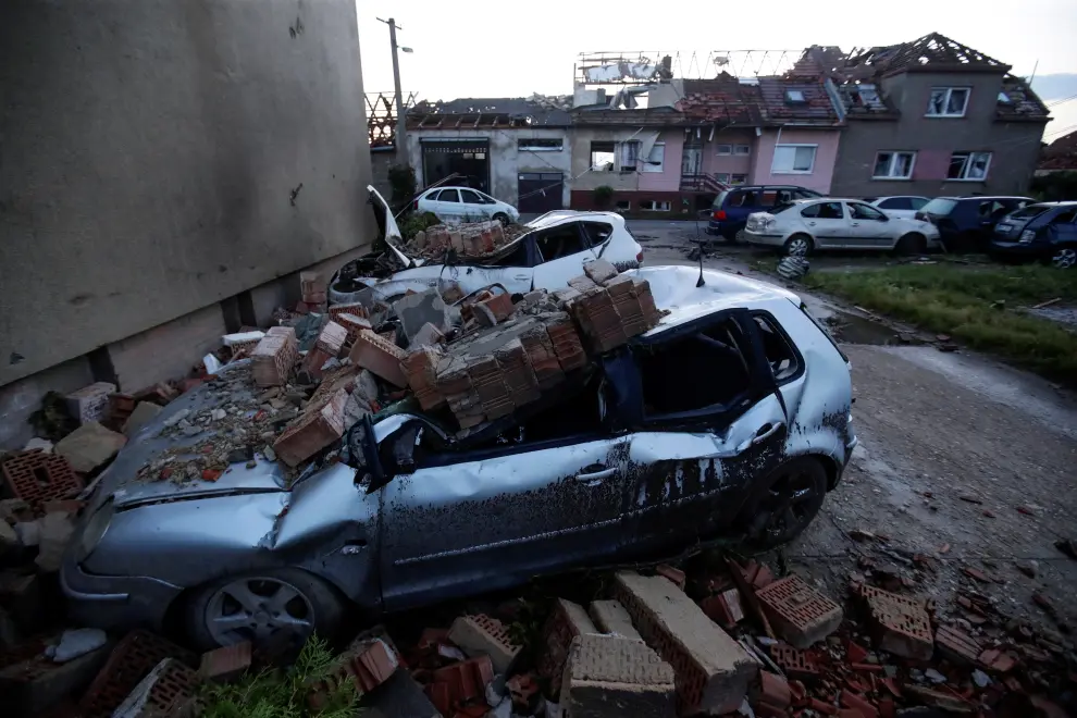 Emergency services personnel sit in front of a building damaged by a rare tornado that struck and destroyed parts of some towns are seen in the village of Moravska Nova Ves, Czech Republic, June 25, 2021. REUTERS/David W Cerny[[[REUTERS VOCENTO]]] CZECH-WEATHER/TORNADO