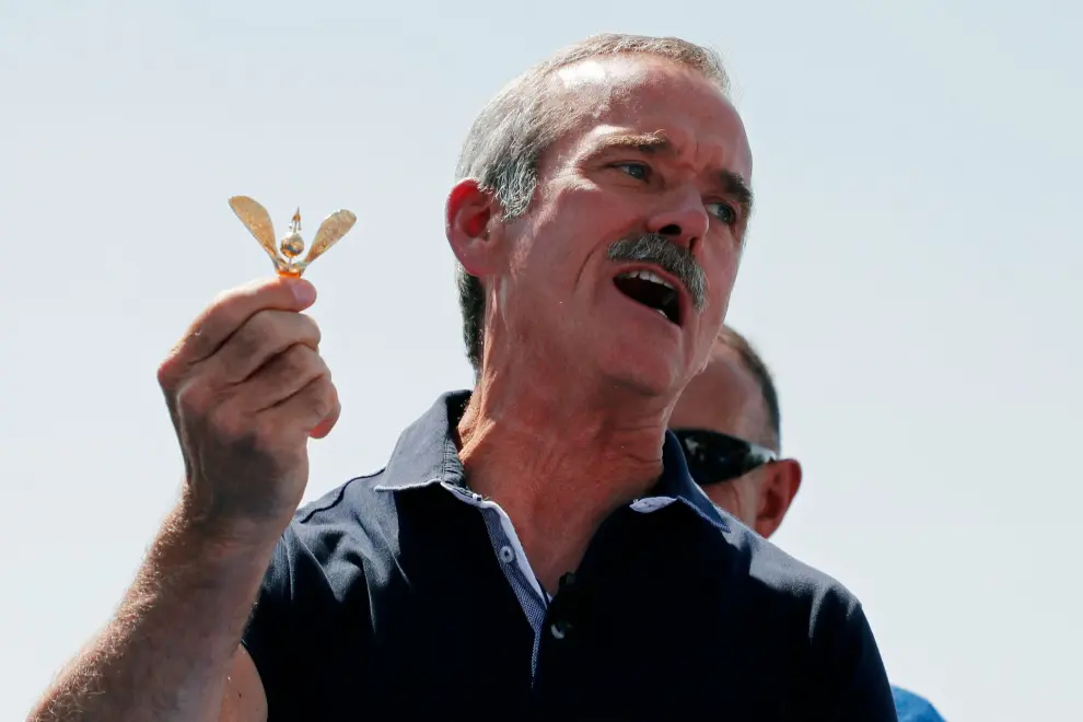 Canadian astronaut Chris Hadfield holds astronaut wings before awarding them to the crew at Spaceport America