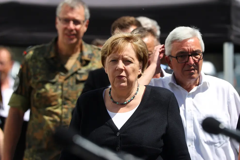 German Chancellor Angela Merkel and Rhineland-Palatinate State Premier Malu Dreyer talk to firefighters and residents during their visit in the flood-ravaged village of Schuld near Bad Neuenahr-Ahrweiler, Rhineland-Palatinate state, Germany July 18, 2021. Christof Stache/Pool via REUTERS[[[REUTERS VOCENTO]]] EUROPE-WEATHER/GERMANY MERKEL