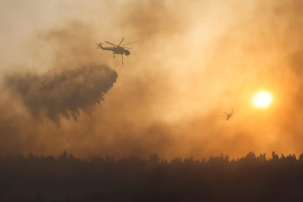 A firefighting helicopter makes a water drop as a wildfire continues to rage at Varympompi suburb north of Athens, Greece, August 4, 2021. REUTERS/Giorgos Moutafis     TPX IMAGES OF THE DAY[[[REUTERS VOCENTO]]] EUROPE-WEATHER/GREECE-WILDFIRES