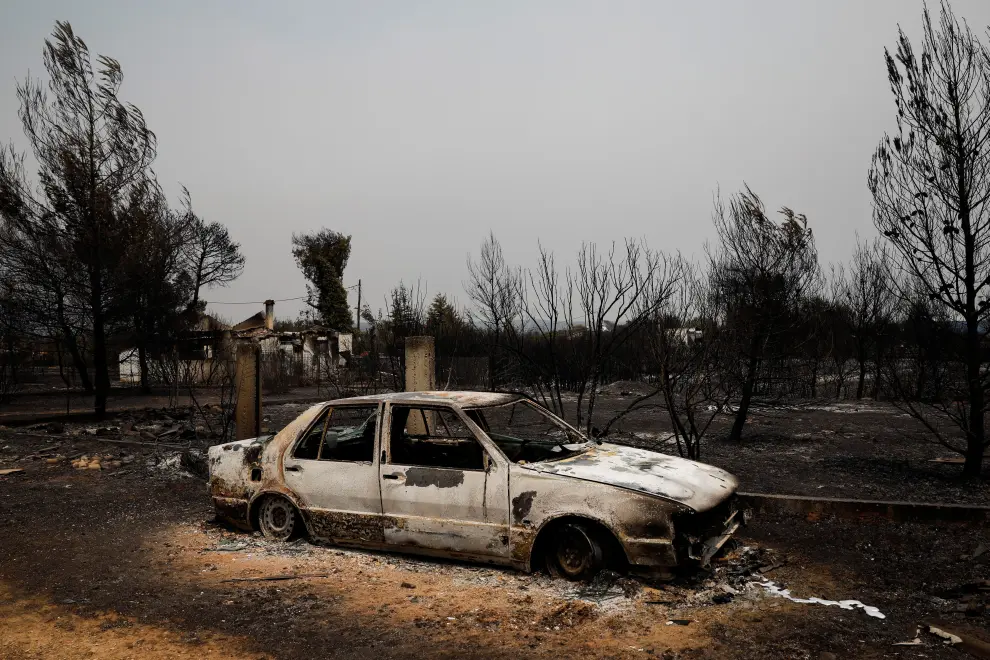 A burnt car is seen following a wildfire in Varympompi suburb, north of Athens, Greece, August 4, 2021. REUTERS/Costas Baltas[[[REUTERS VOCENTO]]] EUROPE-WEATHER/GREECE-WILDFIRES