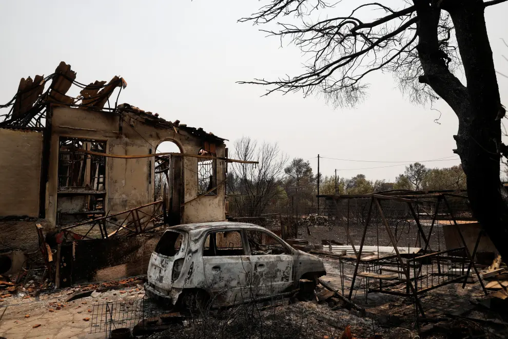 A burnt house and a car are seen following a wildfire in Varympompi suburb, north of Athens, Greece, August 4, 2021. REUTERS/Costas Baltas[[[REUTERS VOCENTO]]] EUROPE-WEATHER/GREECE-WILDFIRES