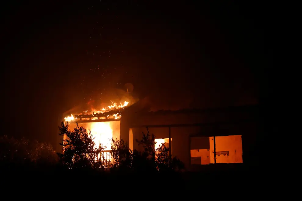 A house burns during a wildfire in the village of Rovies, on Evia island, Greece, August 4, 2021. REUTERS/Costas Baltas[[[REUTERS VOCENTO]]] EUROPE-WEATHER/GREECE-WILDFIRES