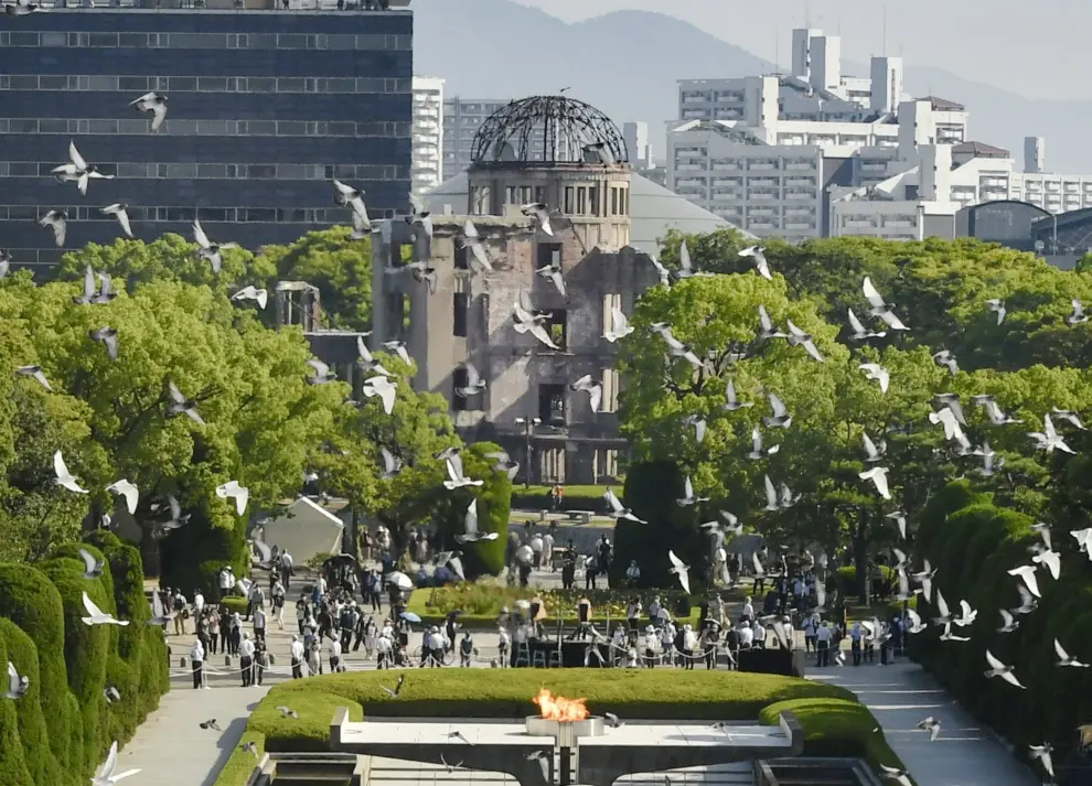 People wearing protective face masks pray in front of the cenotaph for the victims of the 1945 atomic bombing of Hiroshima by the United States, on the 76th anniversary of the bombing, at Peace Memorial Park in Hiroshima, western Japan, August 6, 2021.  Mandatory credit Kyodo/via REUTERS   ATTENTION EDITORS - THIS IMAGE WAS PROVIDED BY A THIRD PARTY. MANDATORY CREDIT. JAPAN OUT. NO COMMERCIAL OR EDITORIAL SALES IN JAPAN.[[[REUTERS VOCENTO]]] WW2-ANNIVERSARY/HIROSHIMA