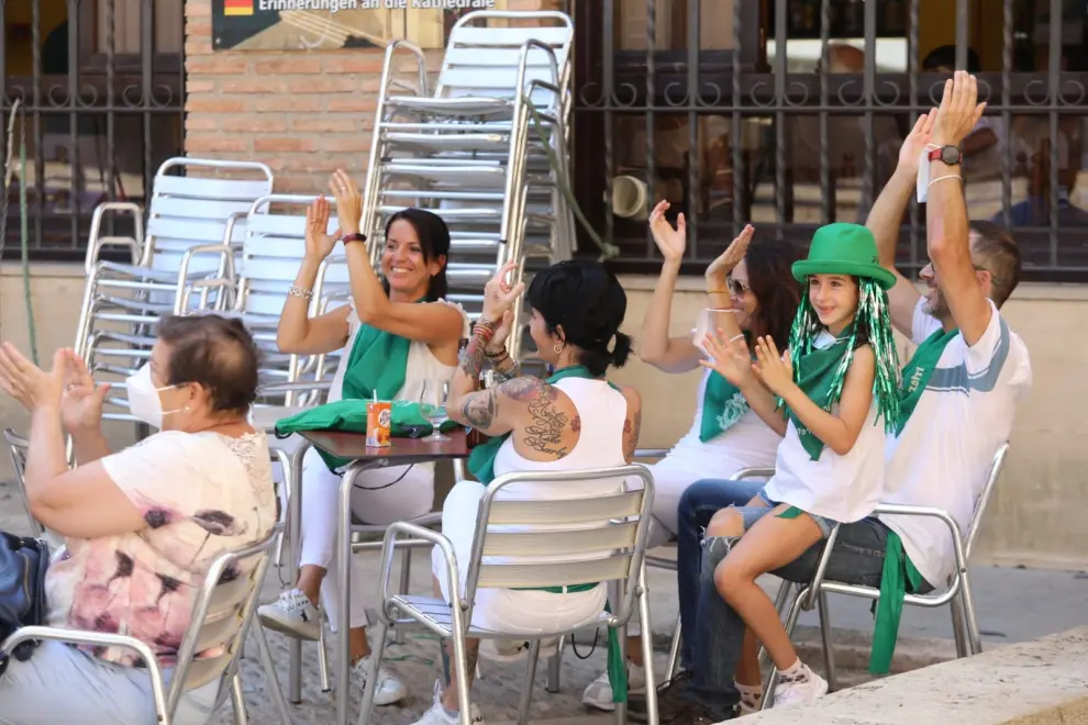 La ciudad de Huesca ha despertado este primer día de las 'no fiestas' de San Lorenzo vestida de blanco y verde, oliendo a albahaca y con la mascarilla como nuevo complemento laurentino.