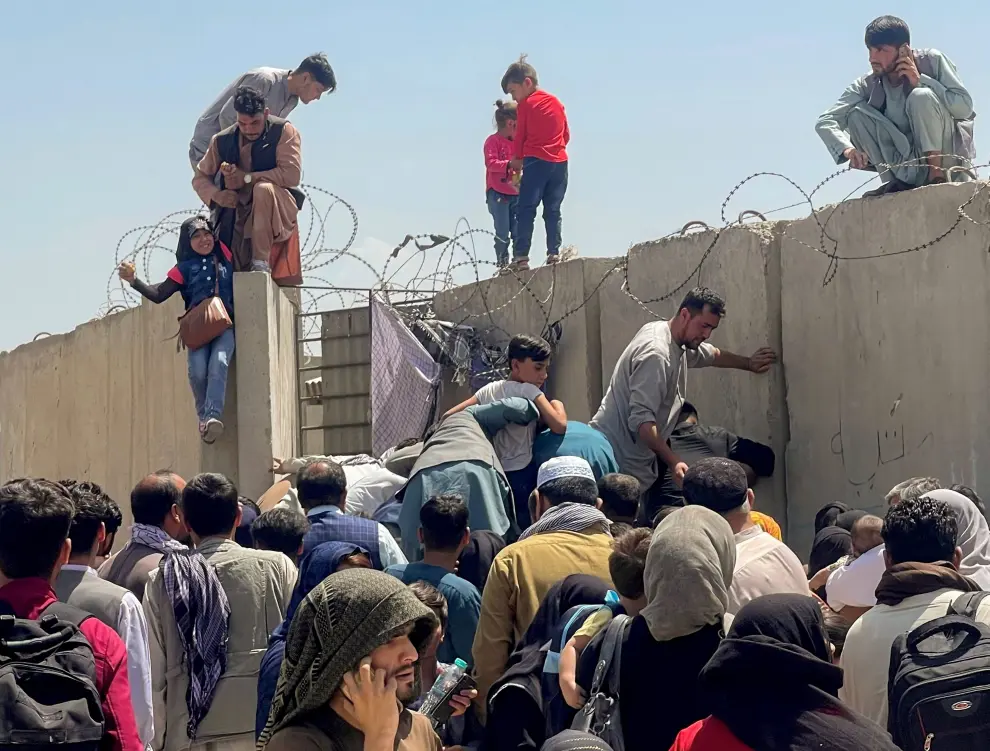 Women with their children try to get inside Hamid Karzai International Airport in Kabul, Afghanistan August 16, 2021. REUTERS/Stringer  NO RESALES. NO ARCHIVES[[[REUTERS VOCENTO]]] AFGHANISTAN-CONFLICT/