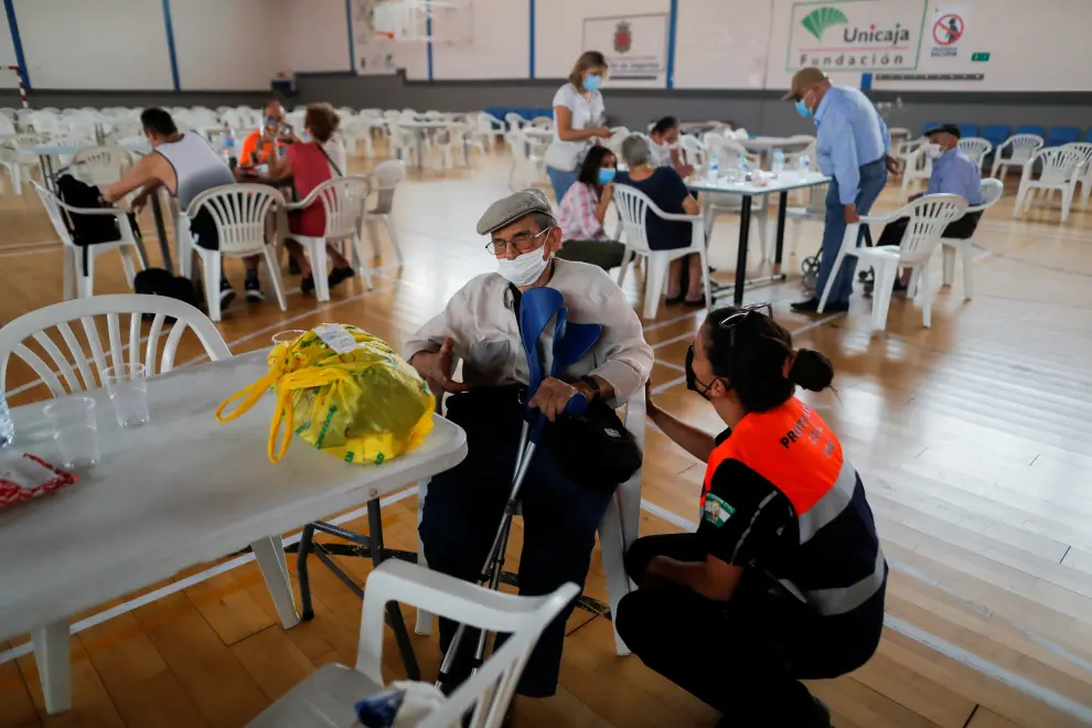 An elderly man is comforted by a member of the emergency team on his arrival at a sports center after he was evacuated, due to a wildfire on Sierra Bermeja mountain, in Ronda, near Estepona, Spain, September 12, 2021. REUTERS/Jon Nazca[[[REUTERS VOCENTO]]] CLIMATE-WILDFIRES/SPAIN