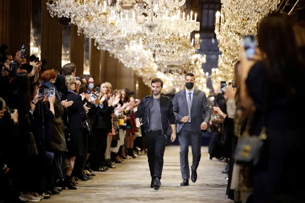 A designer walks on the ramp along with his bodyguard during the Paris Fashion Week in Paris, France, October 5, 2021. REUTERS/Gonzalo Fuentes REFILE - CORRECTING HEADLINE[[[REUTERS VOCENTO]]] FASHION-PARIS/LOUIS VUITTON