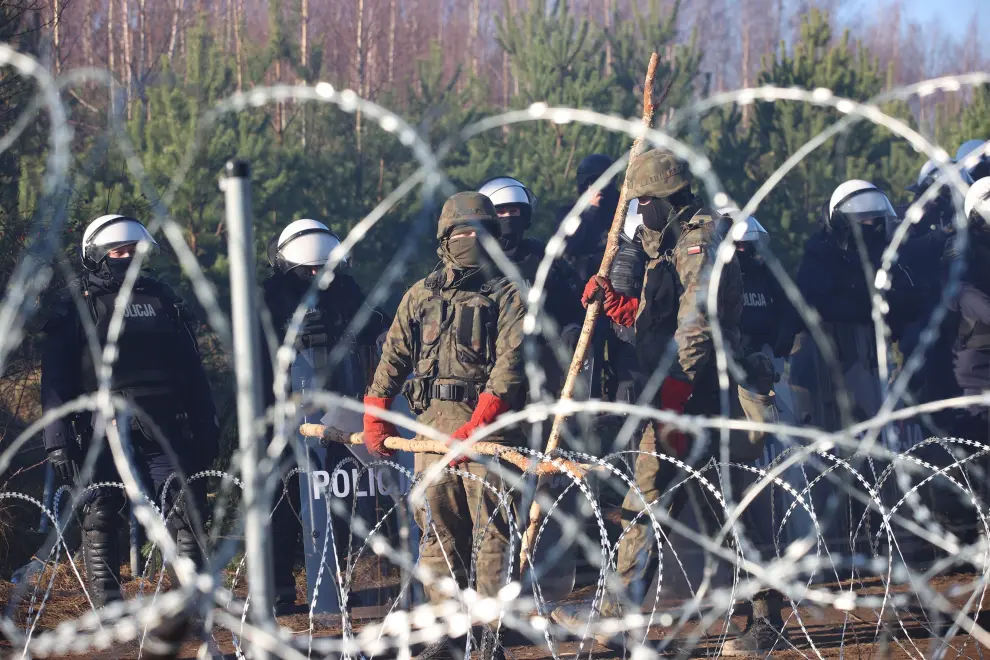 Grodno Region (Belarus), 09/11/2021.- A handout picture made available by Belta news agency shows Polish servicemen guarding the border line as migrants gather at the Belarus-Polish border in the Grodno region, Belarus, 09 November 2021. According to the State Border Committee of Belarus (GPK), there are more than two thousand people near the border, including women and children, who want to obtain asylum in the European Union, 'and they do not consider the territory of the Republic of Belarus as a place of stay.' The territory is guarded by several thousand employees of the Polish special services. The migration crisis at the border of Belarus has been going on since the spring of 2021. Belarusian President Lukashenko said that after the introduction of new EU sanctions against Minsk, the Belarusian authorities will no longer interfere with the movement of illegal migrants to the European Union. (Bielorrusia, Polonia, Estados Unidos) EFE/EPA/LEONID SCHEGLOV/BELTA HANDOUT HANDOUT EDITO