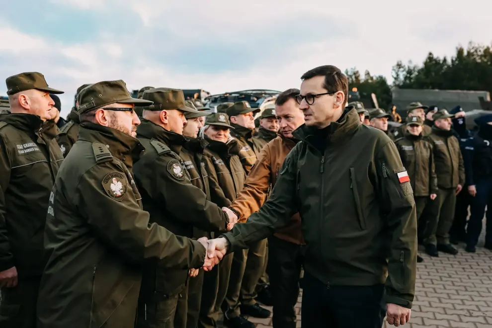 Kuznica (Poland), 09/11/2021.- A handout photo made available by Chancellery of the Prime Minister shows 
Polish Prime Minister Mateusz Morawiecki (2-R), during a meeting with soldiers and officers of the services involved in securing the Polish border with Belarus in the region of Kuznica, eastern-Poland, 09 November 2021. On 08 November morning, the media published information about a large group of migrants planning to cross the Belarusian border with Poland. The Ministry of National Defense informed in the afternoon that the services of the Ministry of Interior and Administration and soldiers had managed to stop the first mass attempt to cross the border. Currently, migrants have set up a camp in the Kuznica region. (Bielorrusia, Polonia) EFE/EPA/ADAM GUZ / CHANCELLERY OF PRIME MINISTER HANDOUT HANDOUT EDITORIAL USE ONLY/NO SALES
 POLAND BELARUS BORDER MIGRATION CRISIS