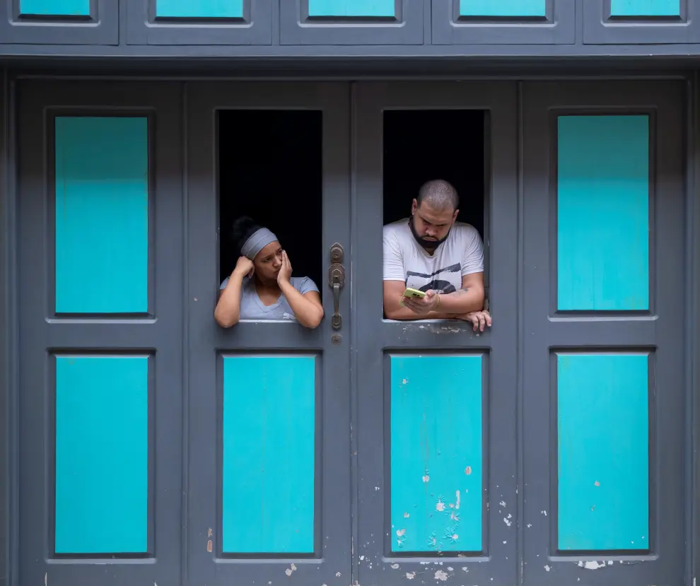 Una pareja se asoma a la ventana de su casa hoy, viernes 12 de noviembre, en La Habana (Cuba).