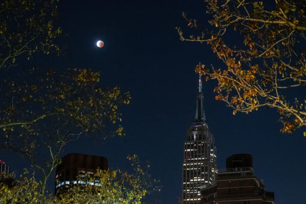 A partial lunar eclipse dubbed the blood moon is seen next One World Trade Center in New York City, New York, U.S.  November 19, 2021. REUTERS/Eduardo Munoz LUNAR-ECLIPSE/BLOODMOON-NEW YORK
