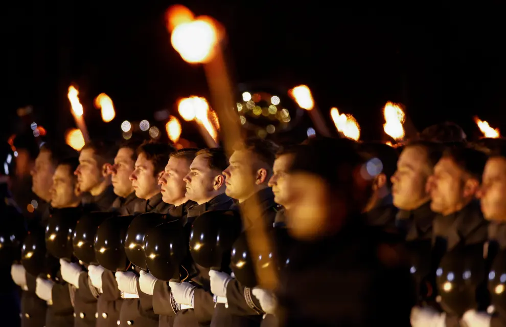 German armed forces members carry torches during a Grand Tattoo (Grosser Zapfenstreich) ceremonial send-off for Chancellor Angela Merkel in Berlin, Germany December 2, 2021. Odd Andersen/Pool via REUTERS GERMANY-MERKEL/CEREMONY