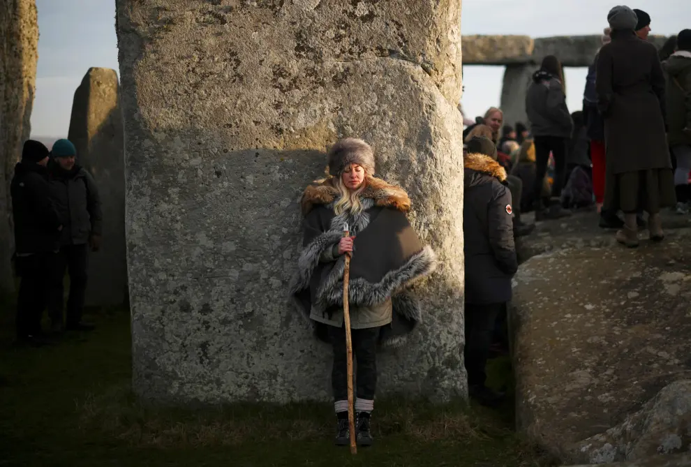 Revellers gather at the Stonehenge stone circle as they welcome in the winter solstice, as the sun rises in Amesbury, Britain, December 22, 2021. REUTERS/Henry Nicholls BRITAIN-SOLSTICE/