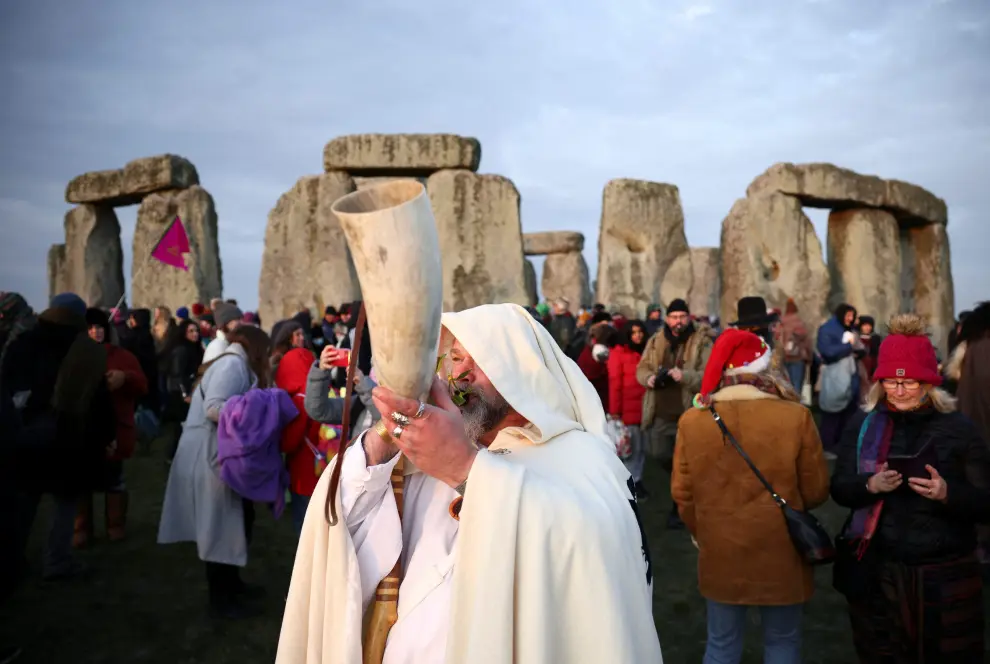 A person rests on the Stonehenge stone circle, as they welcome in the winter solstice, as the sun rises in Amesbury, Britain, December 22, 2021. REUTERS/Henry Nicholls BRITAIN-SOLSTICE/
