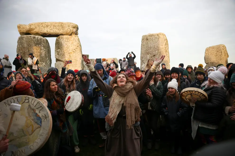 A druid blows a horn at the Stonehenge stone circle, as he welcomes in the winter solstice, as the sun rises in Amesbury, Britain, December 22, 2021. REUTERS/Henry Nicholls BRITAIN-SOLSTICE/