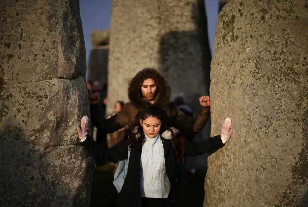 Revellers sing and dance at the Stonehenge stone circle as they welcome in the winter solstice, as the sun rises in Amesbury, Britain, December 22, 2021. REUTERS/Henry Nicholls BRITAIN-SOLSTICE/