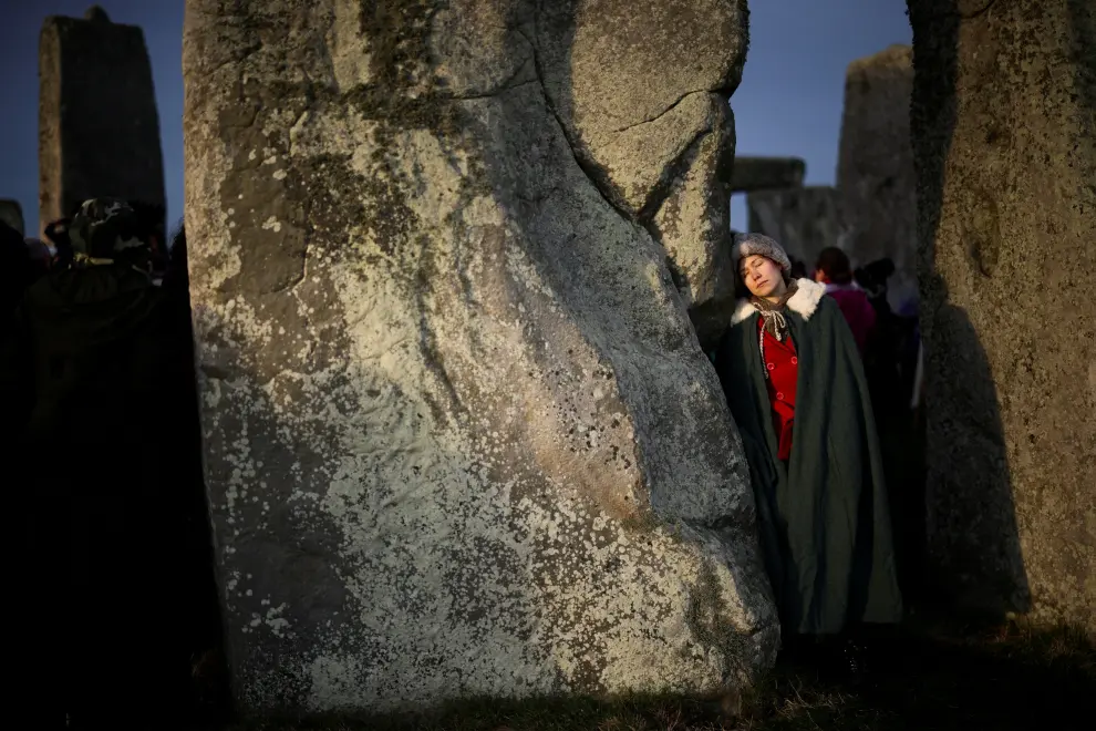 Revellers blow horns at the Stonehenge stone circle, as they welcome in the winter solstice, as the sun rises in Amesbury, Britain, December 22, 2021. REUTERS/Henry Nicholls BRITAIN-SOLSTICE/
