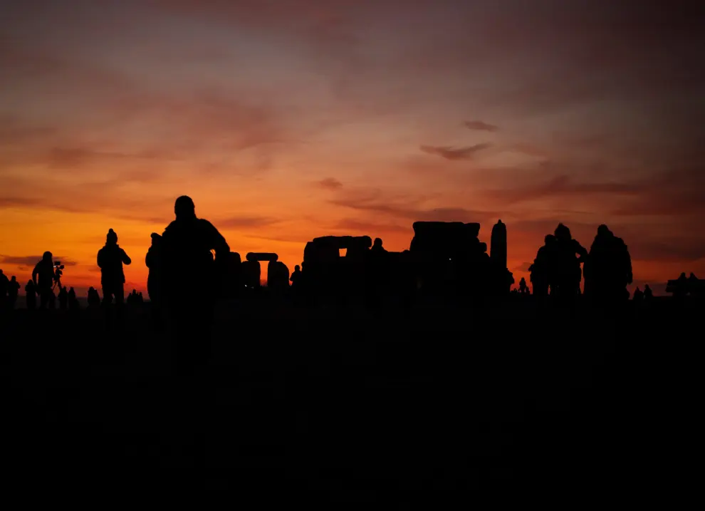 A person rests on the Stonehenge stone circle, as they welcome in the winter solstice, as the sun rises in Amesbury, Britain, December 22, 2021. REUTERS/Henry Nicholls      TPX IMAGES OF THE DAY BRITAIN-SOLSTICE/