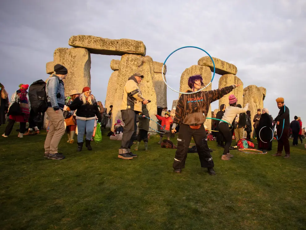 Stonehenge (United Kingdom), 22/12/2021.- A woman touches a stone as druids and revellers gather to celebrate the winter solstice at Stonehenge, Wiltshire, Britain, 22 December 2021. Despite the spread of the Omicron variant of COVID-19, people from across the country travelled to the 5,000 year old ancient site in the South West of England to celebrate the shortest day of the year in the Northern hemisphere. (Reino Unido) EFE/EPA/JON ROWLEY
 BRITAIN WINTER SOLSTICE