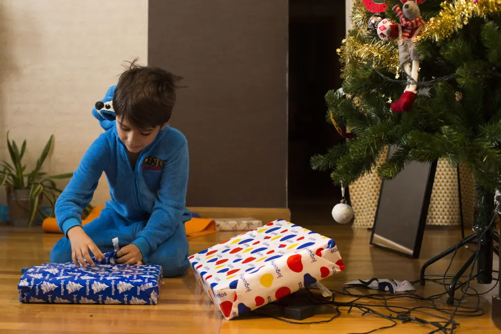 El niño zaragozano Gabriel Galán Muñoz abre, emocionado, sus regalos de Reyes.