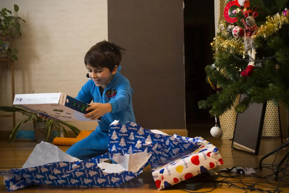 El niño zaragozano Gabriel Galán Muñoz abre, emocionado, sus regalos de Reyes.