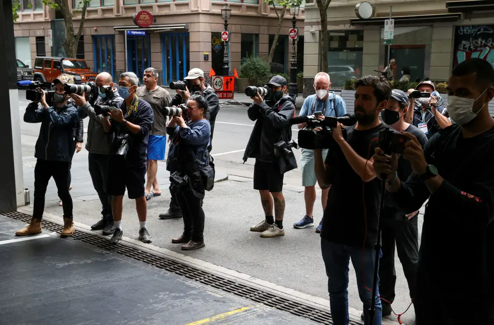 Members of the media gather near the exit of the car park at the offices of Serbian tennis player Novak Djokovic's legal team as police officers stand guard, in Melbourne, Australia, January 15, 2022. REUTERS/Loren Elliott TENNIS-AUSTRALIA/DJOKOVIC