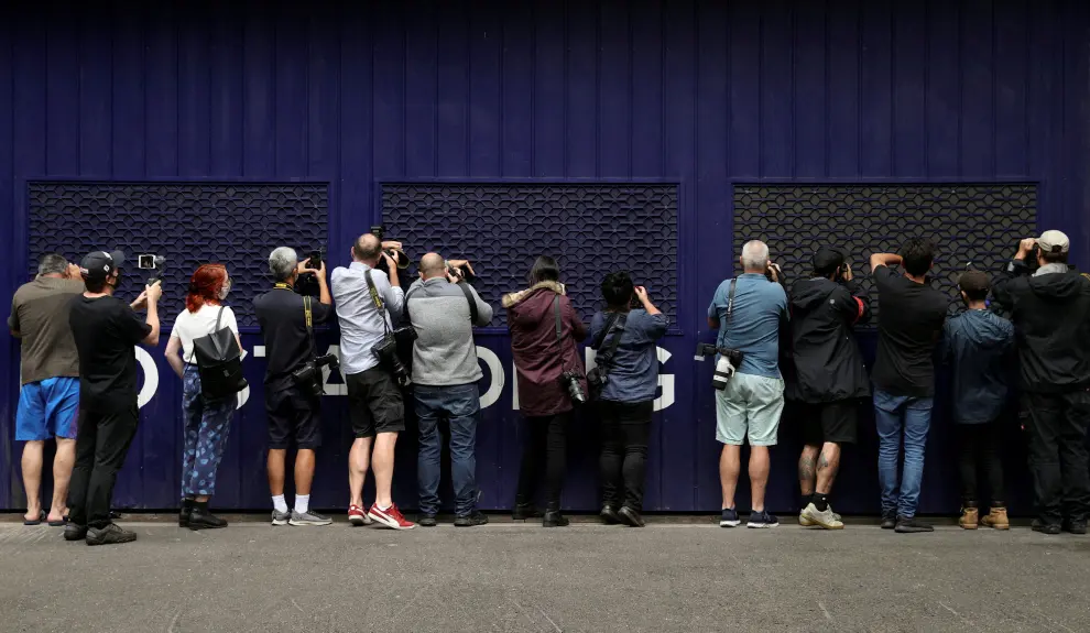 Photographers and videographers peer into a car park trying to get a glimpse of Serbian tennis player Novak Djokovic at the offices of his legal team, after the athlete's visa to play in the Australian Open was cancelled a second time, in Melbourne, Australia, January 15, 2022. REUTERS/Loren Elliott TENNIS-AUSTRALIA/DJOKOVIC