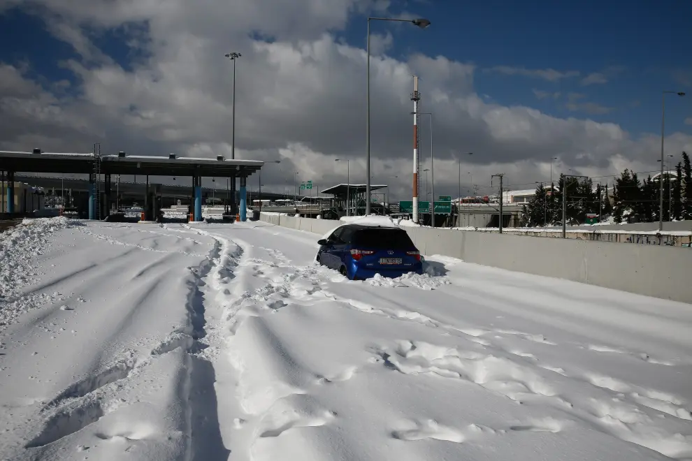 Athens (Greece), 25/01/2022.- A man walks in front of the closed toll station of Attiki odos, the Greek capital's biggest ring road, following a heavy snowfall in Athens, Greece, 25 January 2022. Thousands of motorists are trapped on the highway of Attiki odos in their cars and trucks during the blizzard. A bad weather front, named Elpis by the National Meteorological Services (EMY), has caused frozen temperatures, stormy winds and heavy snowfall since 22 January. (Grecia, Estados Unidos, Atenas) EFE/EPA/YIANNIS KOLESIDIS
 GREECE WEATHER AFTERMATH